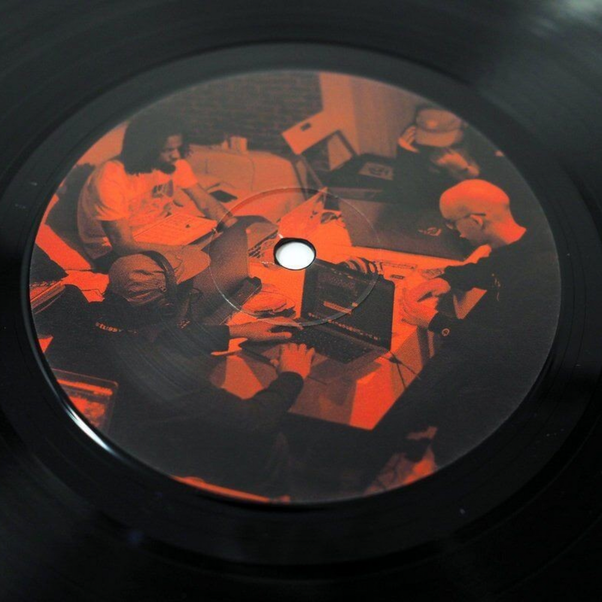 COLD BUSTED Amparo vinyl record center label featuring a red-toned photograph of producers working in a studio.